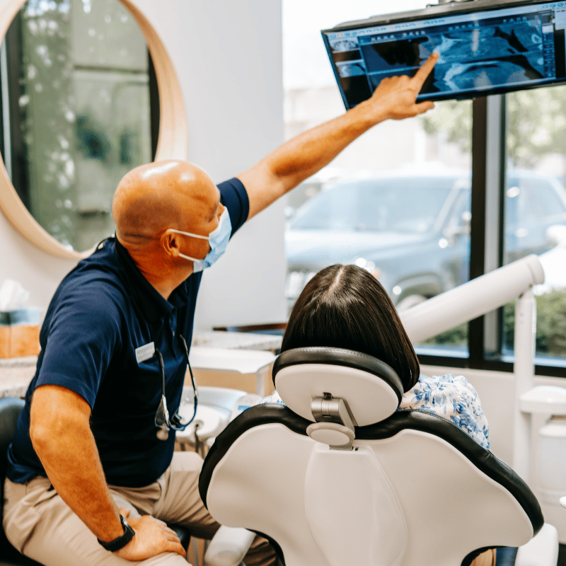 Dentist at Professional Dental in Utah reviewing a dental X-ray with a patient during their consultation
